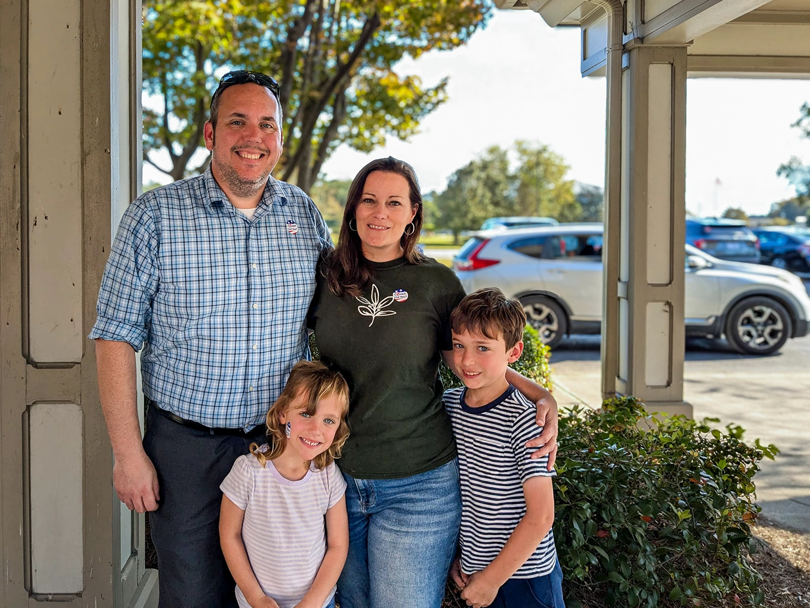 Chris Schulte standing with his wife and kids outside a polling location with an "I Voted" sticker.